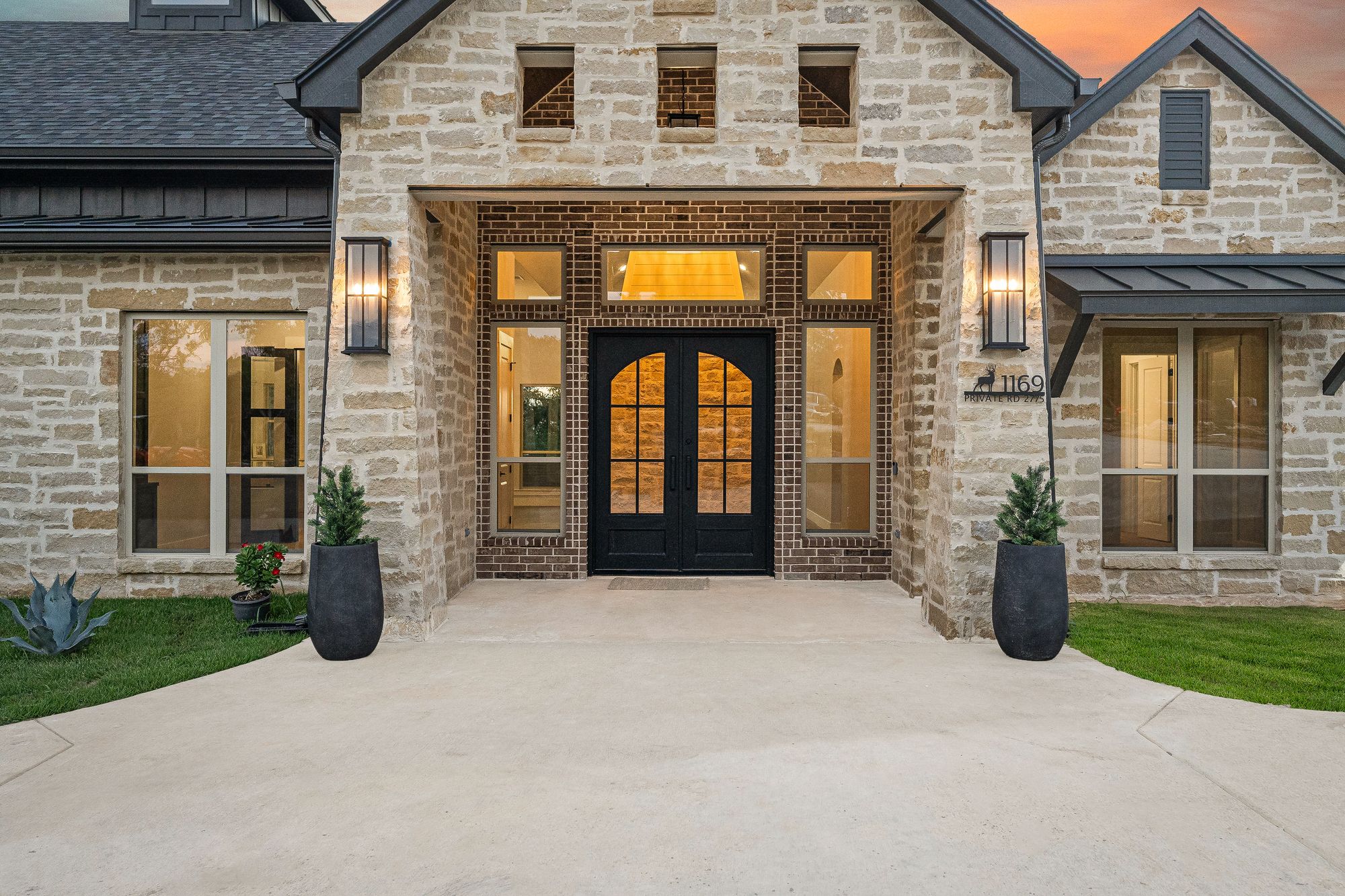 Custom wood-and-glass entry doors at dusk