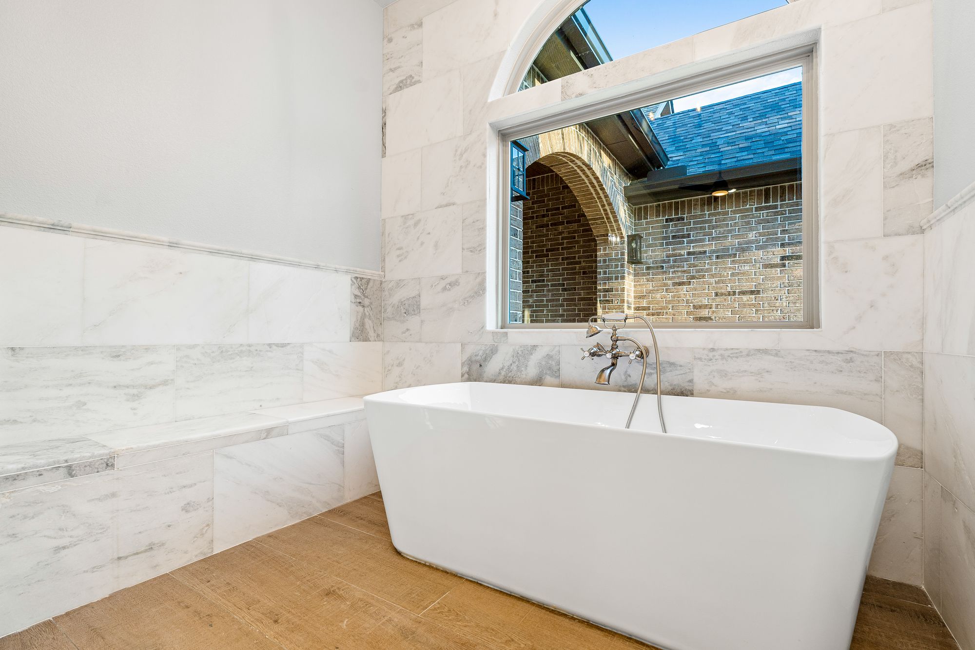 Freestanding tub in marble surround with picture window