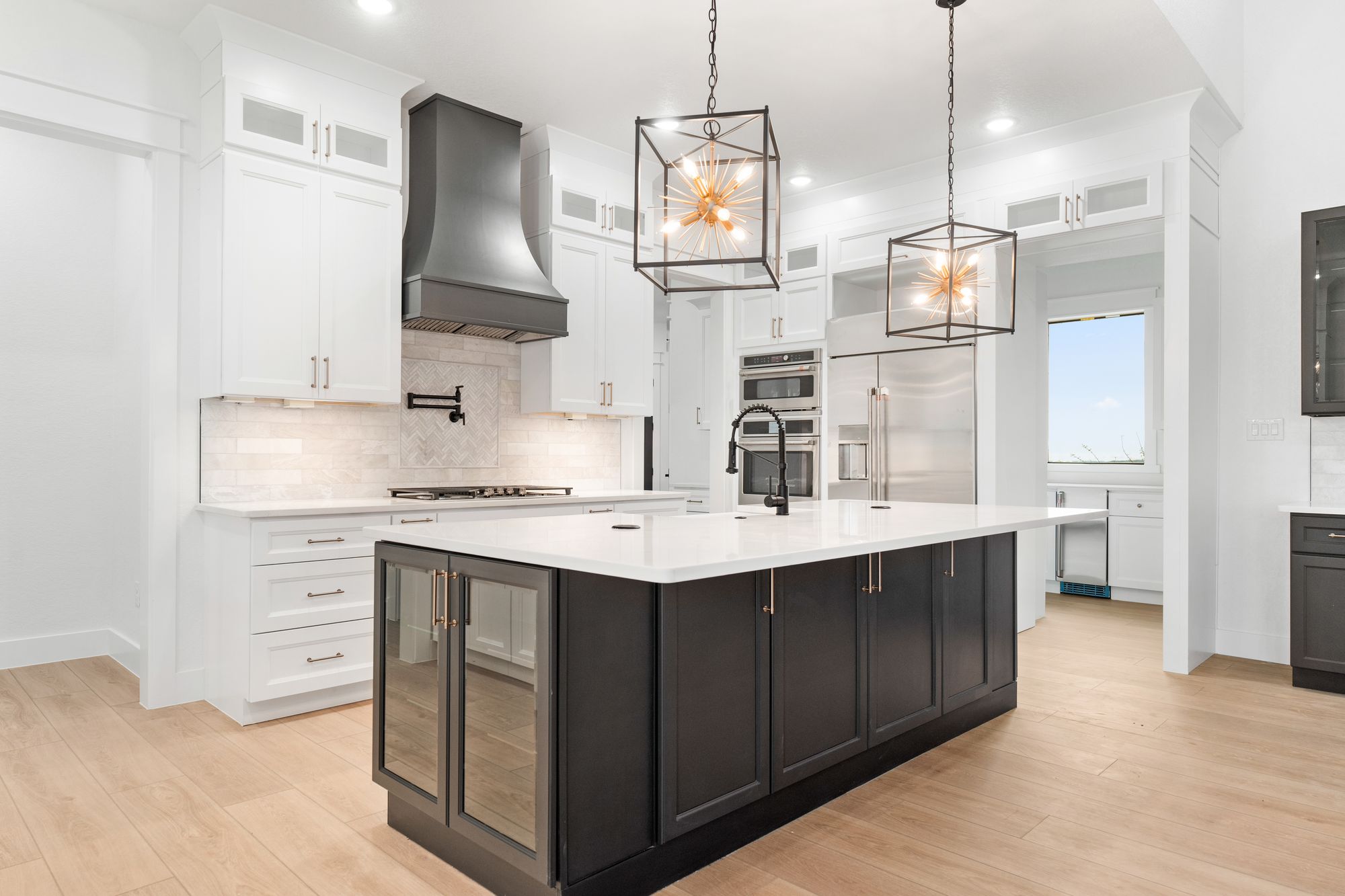 Chef's kitchen with black island and sculptural lighting
