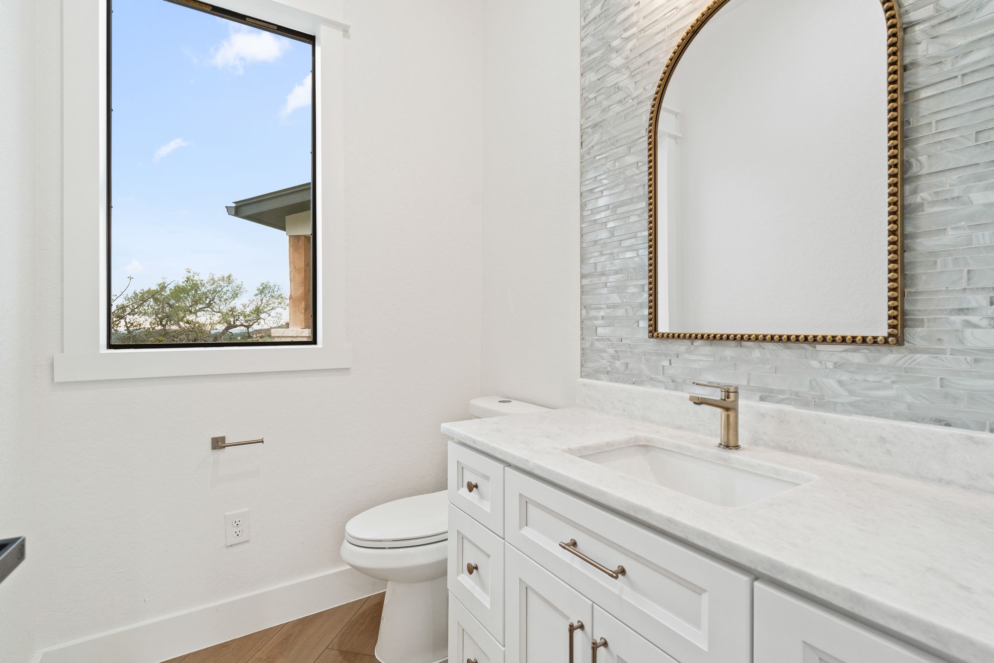 Guest bath with freestanding vanity and arched mirror
